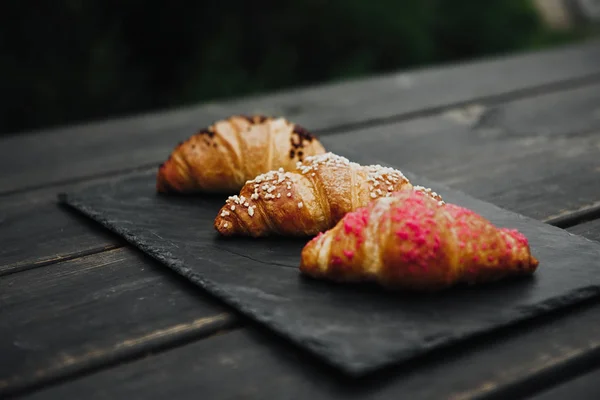 Freshly baked croissants on wooden cutting board — Stock Photo, Image