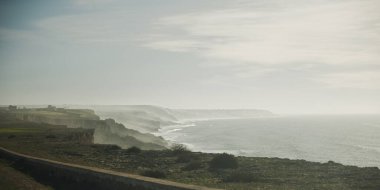 Dalgaların kayalıklara çarptığı engebeli bir kıyı şeridi.