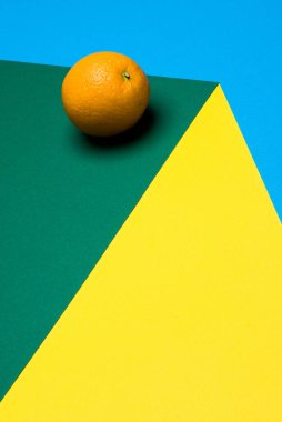 Renkli arka planda portakal meyvesi, renkli kağıtta portakal yarıları. Boşluğu kopyala.