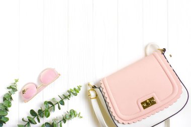 Yakın plan pembe çanta ve yapraklı güneş gözlüğü. 