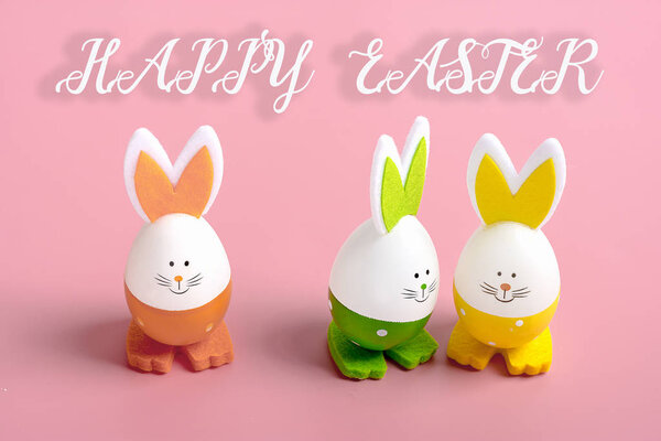 set of easter bunnies in shape of eggs on pink