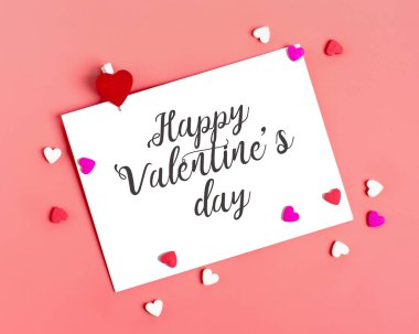 Sevilen birine mesaj göndermek için beyaz bir sayfa, pembe arka planda kalp şeklinde kırmızı bir zarf ve şeker. Mutlu sevgililer günü konsepti Düz yatış Üst görünüm için yer