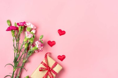 Farklı pembe karanfil demetleri, hediye kutuları, pembe arka planda kalpler düzlük tatil kartı 8 Mart, Sevgililer Günü, Anneler Günü konsepti