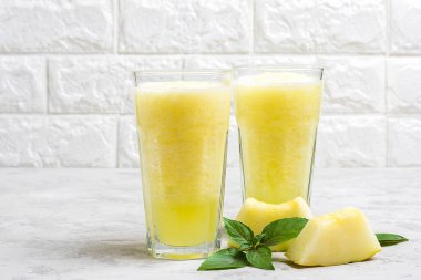 Kavun limonata, buzlu smoothie ve gri masada bir bardakta fesleğen. Yaz ferahlatıcı ve detoks içeceği, Rustik tarzı Top view