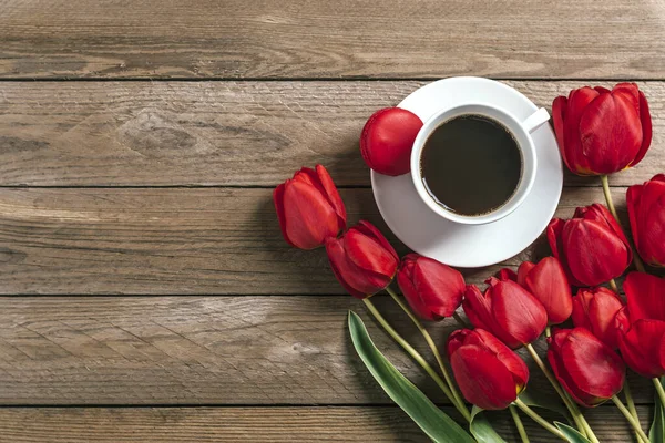 Rad av röda tulpaner, kopp svart kaffe americano på trä bakgrund. Utrymme för sms och meddelanden. Morsdag, Hej våren, god morgon koncept. Kort. Ett platt ligg. Högst upp. Rustik stil — Stockfoto