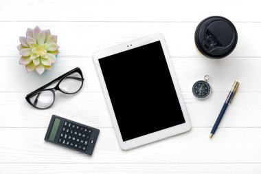 Merkez ofis çalışma alanı. Tablet, hesap makinesi, not defteri, altın kalem ve ataçlar, bardaklar, kahve fincanı, beyaz ahşap arka planda sulu. Üst görünüm Düzleştir