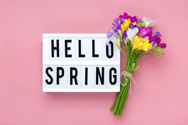 フリージアの花の花束 テキスト付きのライトボックスピンクの背景にこんにちは春花の休日カードトップビューフラットレイ春のコンセプト — ストック写真