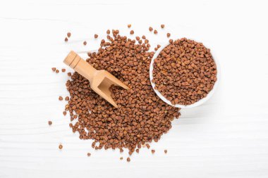 Tahta kasede kahverengi karabuğday taneleri izole edilmiş beyaz arka planda sağlıklı yiyecekler, süper yiyecek kavramı