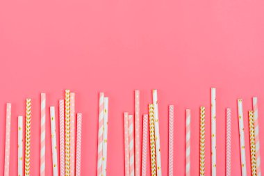Pembe pastel arka planda altın, beyaz, pembe şeritli ve fotokopi alanı olan parti için kağıt pipetler içmek. Renkli kağıt kullan-at eko manzarası. Yaz kokteylleri için dost pipetler. Düz yatıyordu.