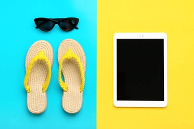 Yüzme aksesuarları - modaya uygun siyah gözlükler, yaz terliği, mavi tablet, sarı arka plan düz yatar Top view Seyahat, tatil, online rezervasyon konsepti.