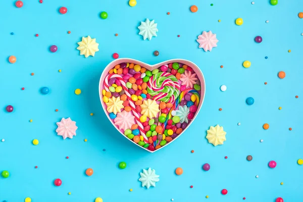 Mix färgglada choklad godis ligger i presentförpackning form av hjärta på färgglada bakgrund Platt låg Ovanifrån — Stockfoto
