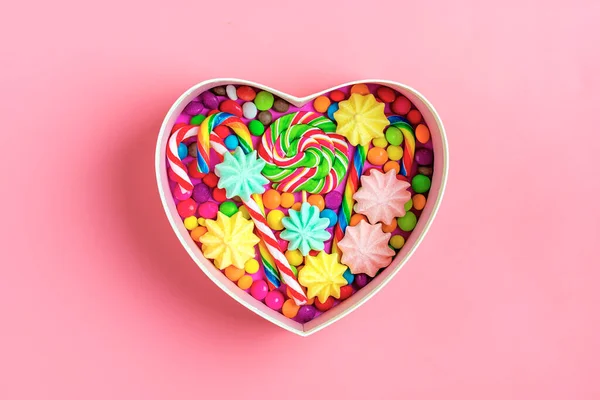 Mix colorful chocolate sweets lie in gift box shape of heart on colorful background Flat lay Top view — Stock Photo, Image