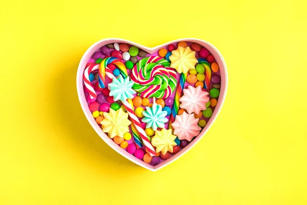 Mix colorful chocolate sweets lie in gift box shape of heart on colorful background Flat lay Top view — Stock Photo, Image