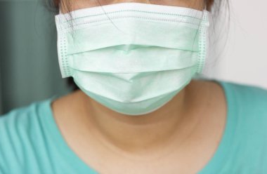 Yüz maskesi takan kapalı bir kadın şehirde mikrop ve virüsleri, toz bulutlarını ve hava kirliliğini önlüyor..