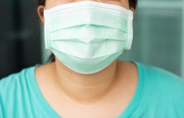 Yüz maskesi takan kapalı bir kadın şehirde mikrop ve virüsleri, toz bulutlarını ve hava kirliliğini önlüyor..