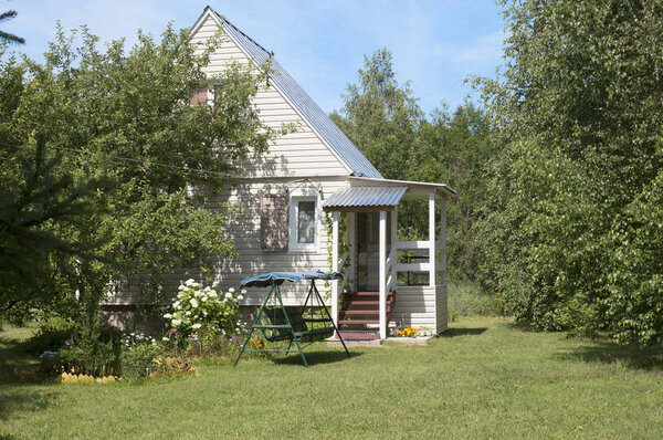 Small summer country house in the shade of garden trees