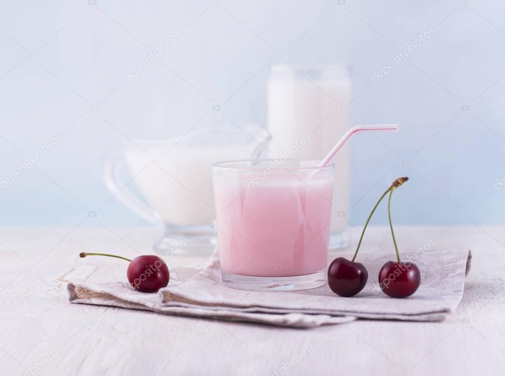 Glasses of milk and delicious milkshake and fresh berries on whi