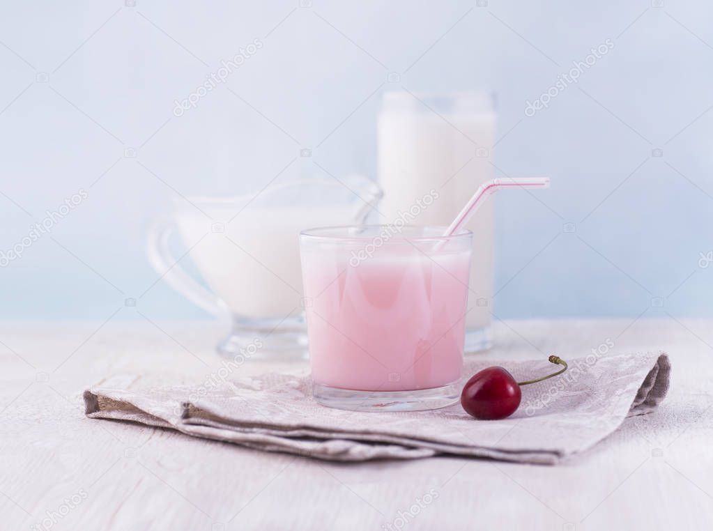 Glasses of milk and delicious milkshake and fresh berries on whi