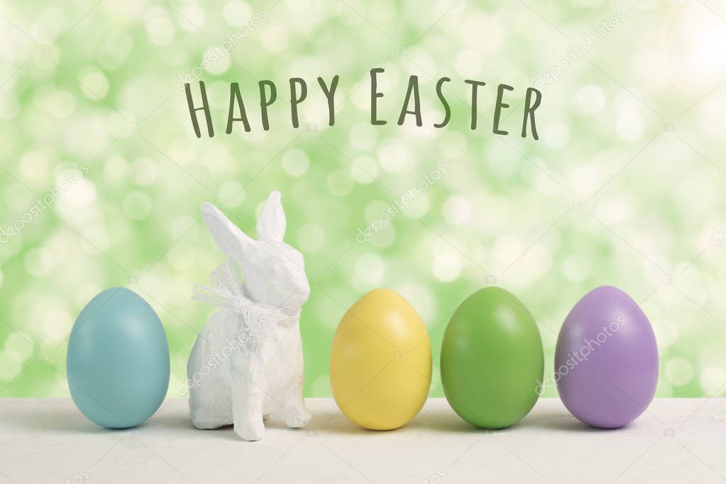 Easter eggs and bunny on blurred green background