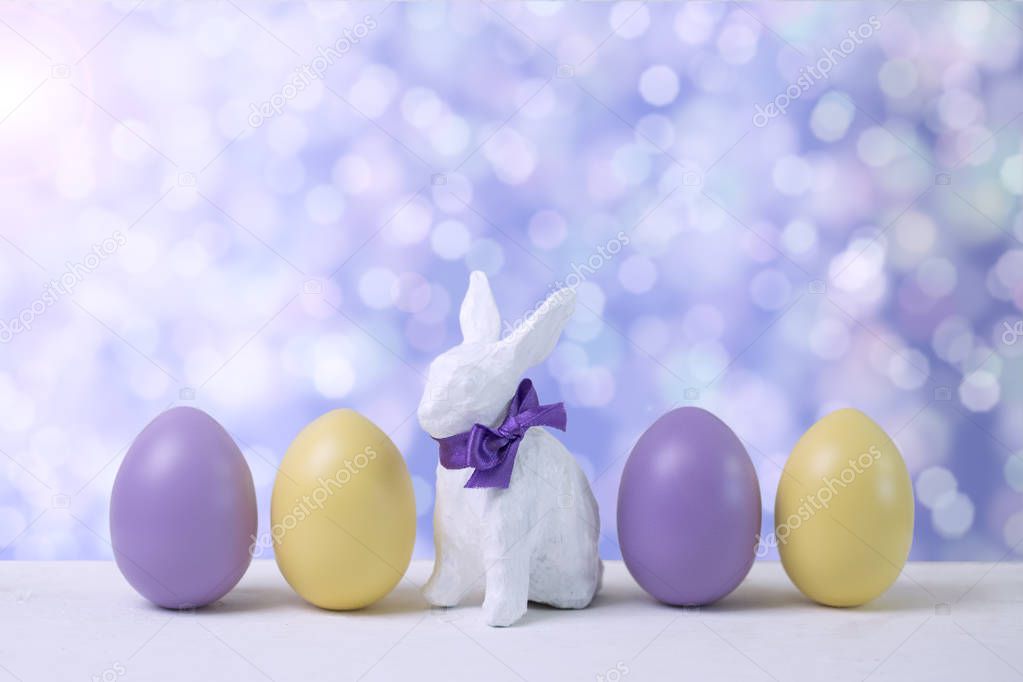 Easter bunny and eggs on a blurred violet background