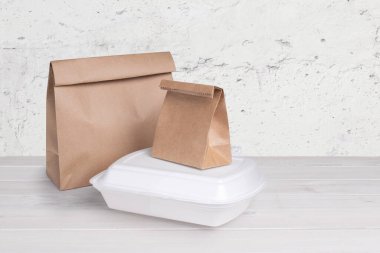 Kağıt torbalar ve beslenme çantası beyaz ahşap arka planda izole edilmiş.