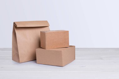 Karton kutular ve kağıt torba beyaz ahşap arka planda izole