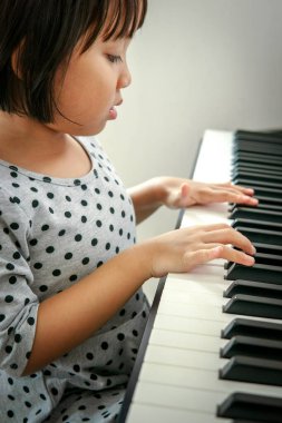 Piyano çalan küçük Asyalı kız.