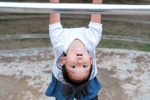 かわいいアジアの子供は 村の公園の遊び場でプルアップバーにぶら下がっています 子供のためのスポーツ屋外活動 — ストック写真