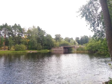 Nehir ya da göl üzerinde küçük bir köprü. Soğuk kuzey yazının sakin renkleri.