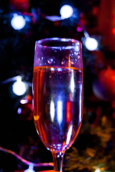 Eén glas champagne tegen de achtergrond van blauwe wazige lichten. Gelukkige Valentijnsdag Valentijnsdag Valentijnsdag Kerstmis mystieke mousserende wijn drinken bellen vakantie in eenzaamheid asociaal — Stockfoto