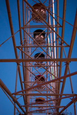 Dönme dolap aşağıdaki kabinleri gösteriyor. Dikey fotoğraf