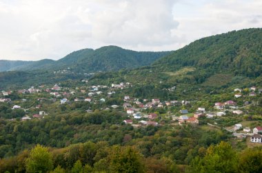 Dağ manzarası - yaz, dağlar, gökyüzü ve ovalardaki küçük evler.