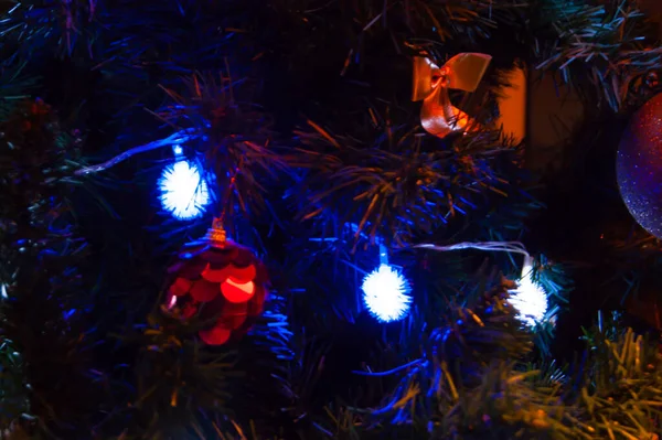 Κόκκινες μπάλες και φιόγκους για τα Χριστούγεννα ή χριστουγεννιάτικο έλατο, λάμπει μπλε γιρλάντα φώτα. Διακοπές ευτυχία μυστικιστικό δώρα η ζωή του το θαύμα διακόσμηση του εσωτερικού του σπιτιού — Φωτογραφία Αρχείου