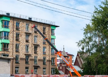 Fakir bir şehir. Yeni bir tuğla konut inşaatı. Turuncu ok inşaat malzemelerini beslemek için binaya ulaşıyor..