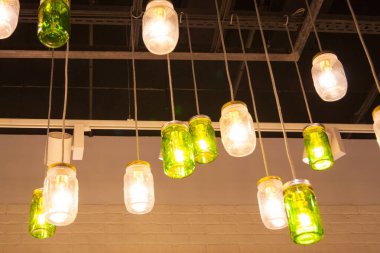 İç tasarımın bir elementi, farklı renklerde boyanmış konserve camından yapılmış koyu bir tavanın altındaki tavan ışıkları.