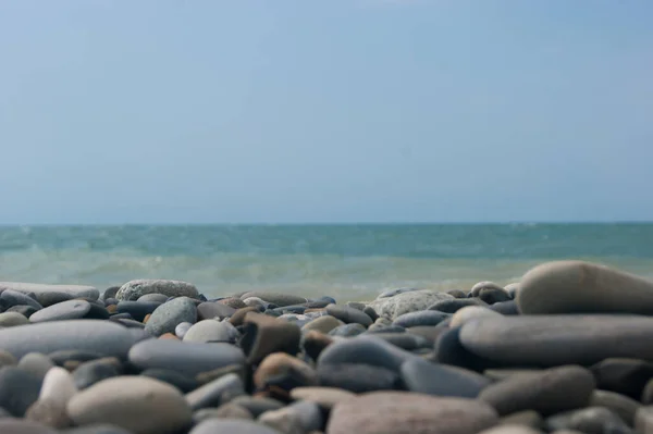 Tengerpart. Kilátás a tengerre és sima horizont a kavicsos strandtól. Az előtérben nagy kavicskövek vannak.. — Stock Fotó