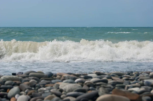 La ola de mar del Mar Negro es una playa de guijarros. Horizonte liso, cielo azul. — Foto de Stock