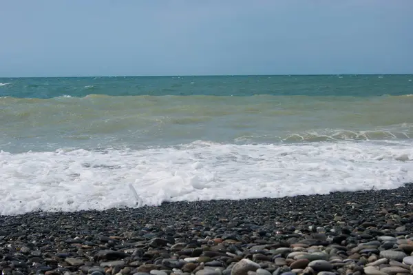 海一度心配している 黒海の小さな嵐の後に少し泥だらけの水 澄んだ空と滑らかな水平線 ビーチでぬれた大きな小石 夏のビーチ休暇は幸福の自由の暖かさです — ストック写真