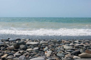 Denizde üç ya da dört noktalı küçük bir fırtına, dalga kıyıya büyük bir çakıl taşıyla vurur. Karadeniz, yaz tatili plaj seyahati