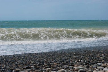 Deniz bir zamanlar endişeliydi. Küçük bir fırtınadan sonra Karadeniz 'in çamurlu suları. Deniz, berrak gökyüzü ve düz ufuk çizgisi, dalga, kumsalda ıslak büyük çakıl taşları. Yaz tatili mutluluğun sıcaklığıdır.