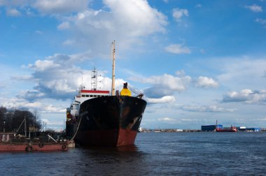 Rusya, Arkhangelsk - Mayıs 2020. Arkhangelsk deniz ticaret limanı, büyük bir Rus kuzey limanı. Rıhtım, iskele. Bahar Nehri ve mavi gökyüzü beyaz bulutlarla