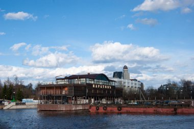 Rusya, Arkhangelsk - Mayıs 2020. Arkhangelsk deniz ticaret limanı, büyük bir Rus kuzey limanı. Rıhtım, iskele. Bahar Nehri ve mavi gökyüzü beyaz bulutlarla