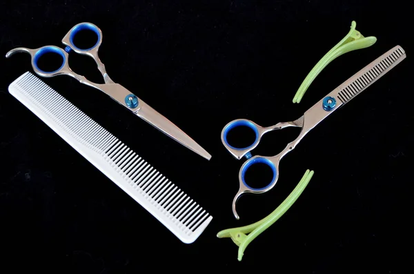 Ножницы и щетки для волос на черном фоне — стоковое фото
