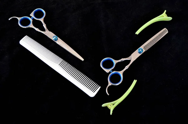 Scheren und Bürsten für Haare auf schwarzem Hintergrund — Stockfoto