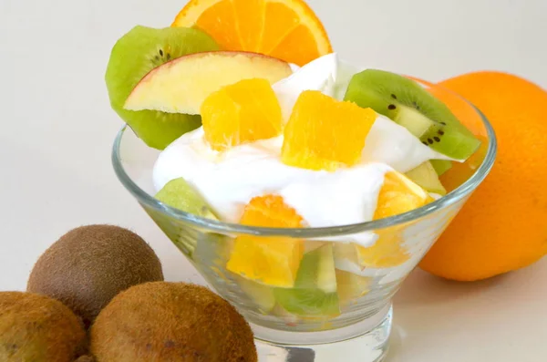 Десерт - фрукты со сливками, киви, яблоком и апельсином — стоковое фото