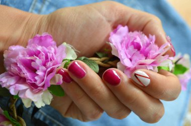 Kısa kırmızı çivi ve işaret parmağı üzerine beyaz manikür