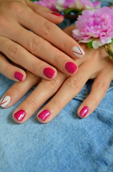 Manicure korte rode nagels en wit op de wijsvinger — Stockfoto