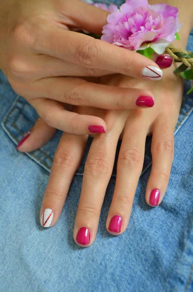 Manicure korte rode nagels en wit op de wijsvinger — Stockfoto