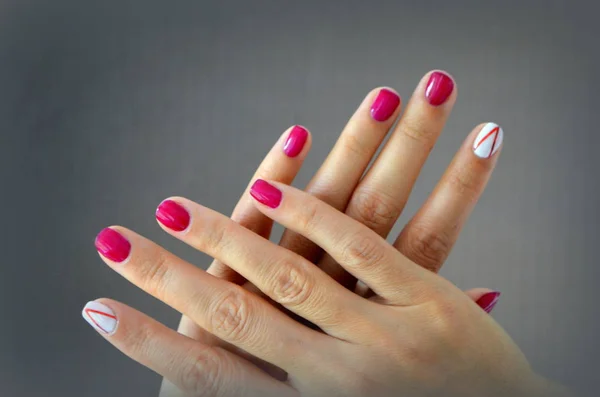 Manicura uñas rojas cortas y blancas en el dedo índice —  Fotos de Stock