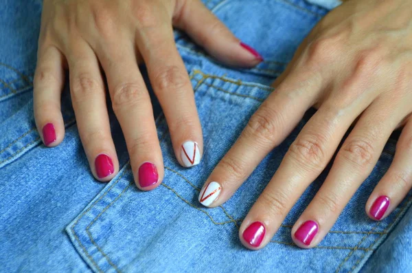 Manicure korte rode nagels en wit op de wijsvinger — Stockfoto